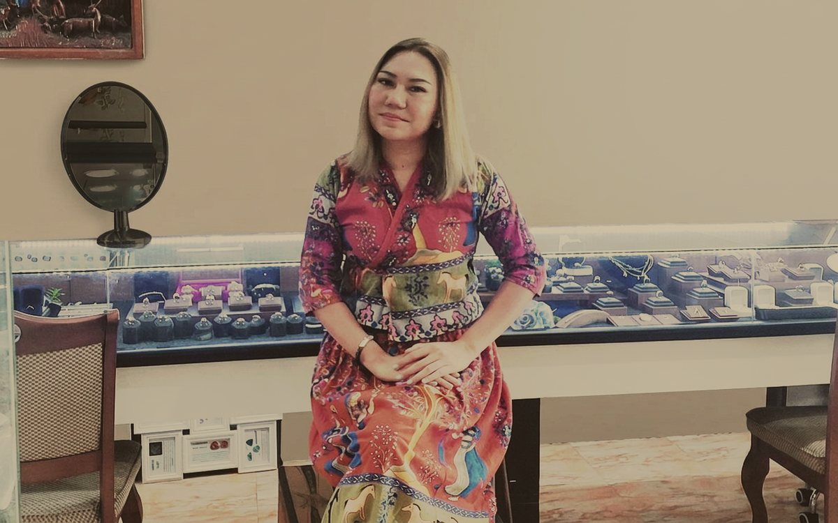 Elle seated at the display counter inside her Pattaya workshop